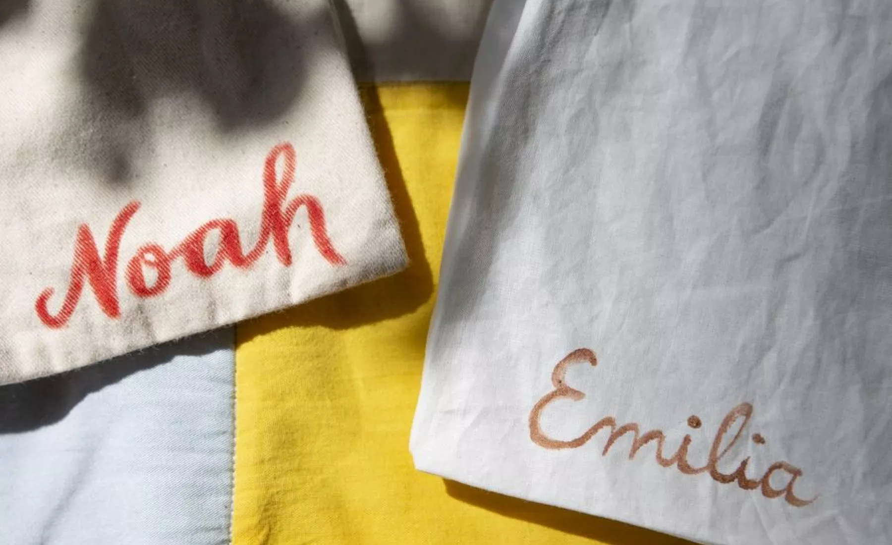 Stoffbeutel mit den Namen «Noah» und «Emilia» liegen nebeneinander