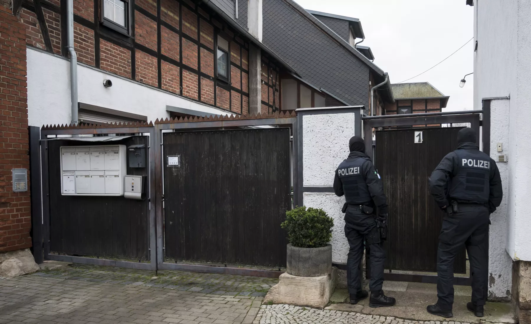 Polizisten stehen vor einem Wohnhaus in Erfurt Vieselbach