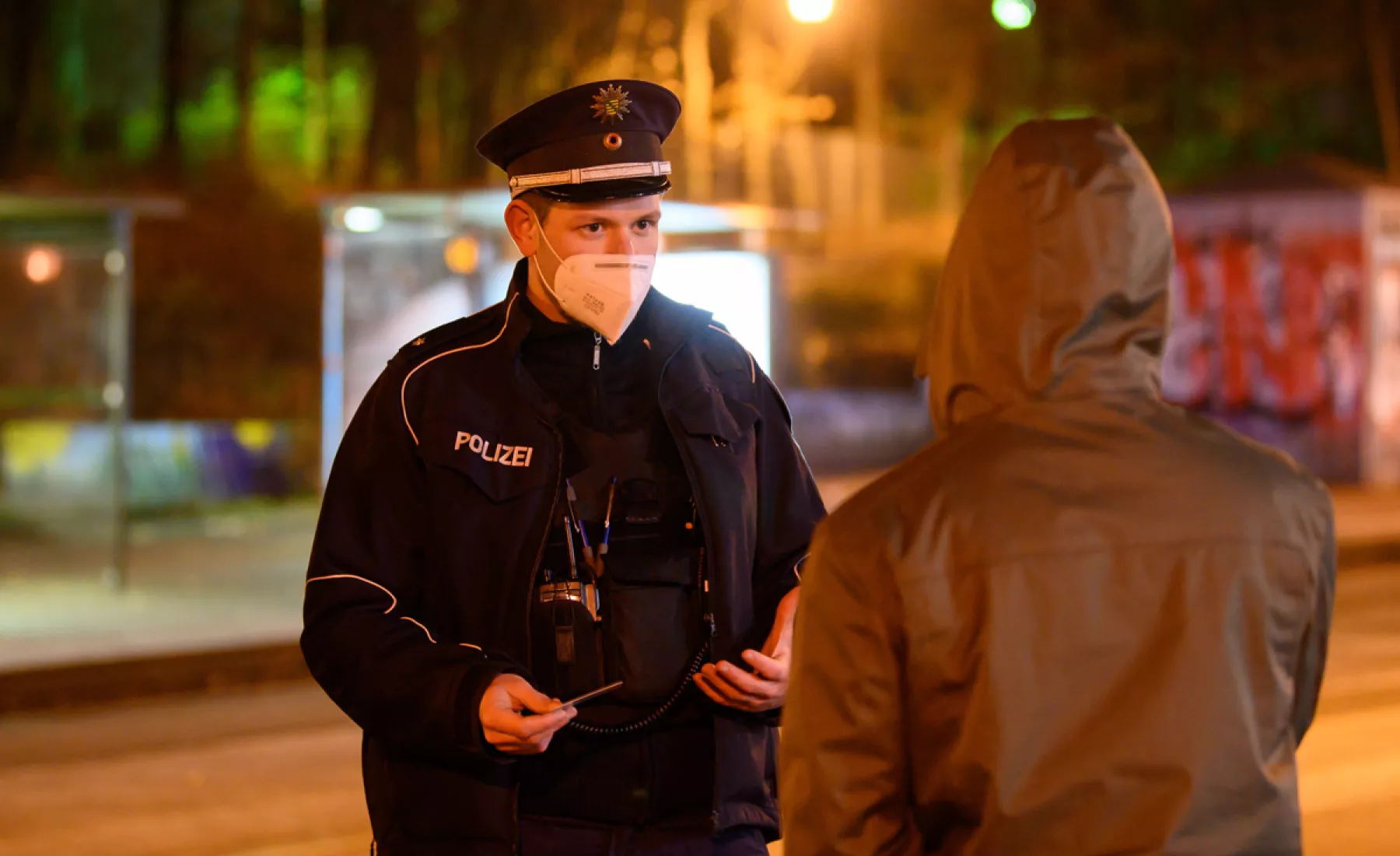 Polizist kontrolliert Passanten
