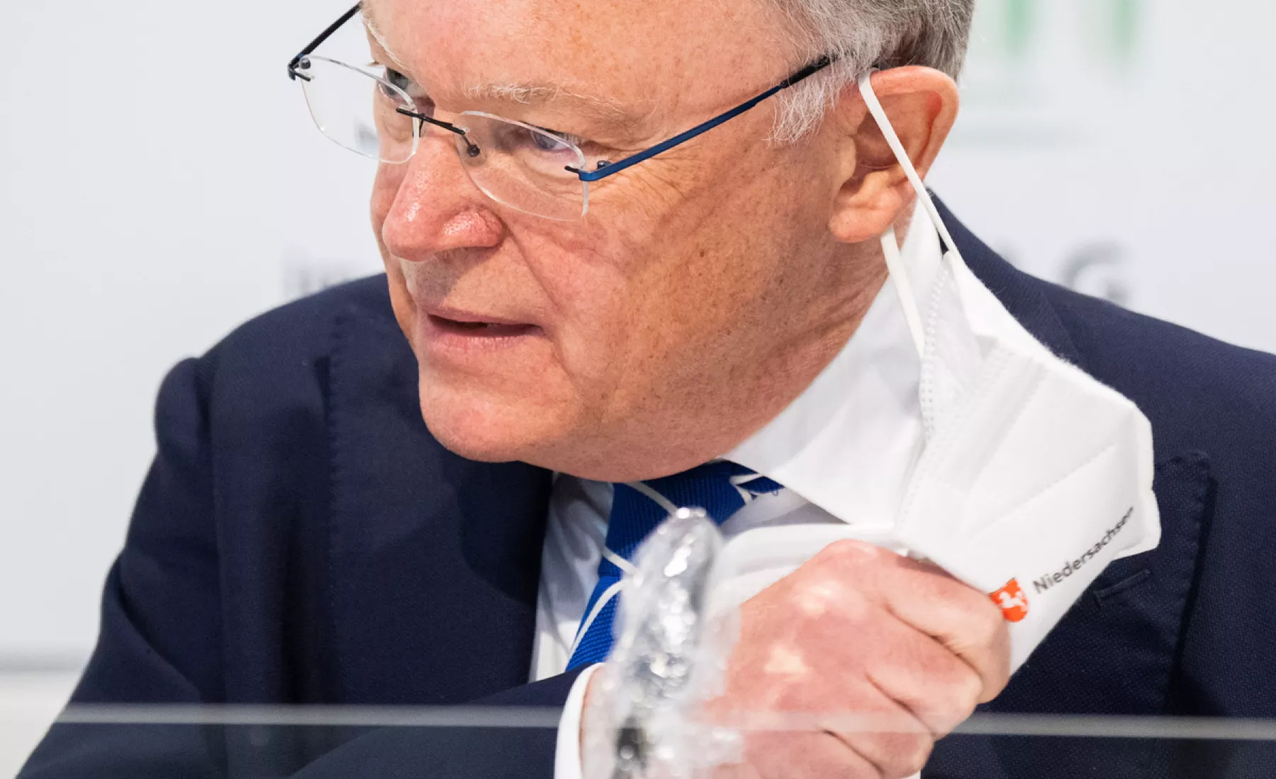 Stephan Weil (SPD), Ministerpräsident Niedersachsen, nimmt in die Landespressekonferenz im Landtag Niedersachsen seine Maske ab.