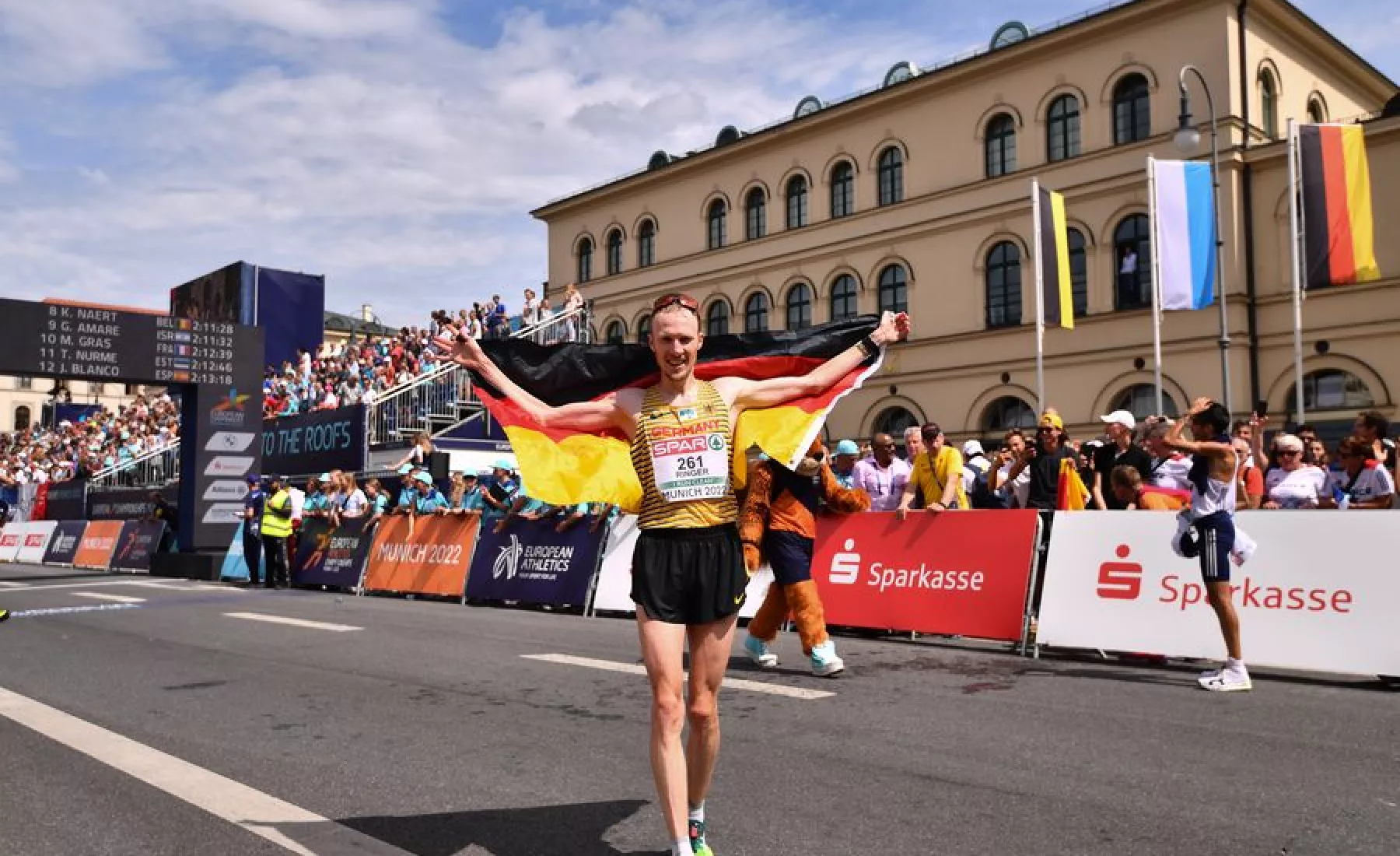 Richard Ringer gewinnt das Rennen und jubelt mit der deutschen Fahne im Ziel