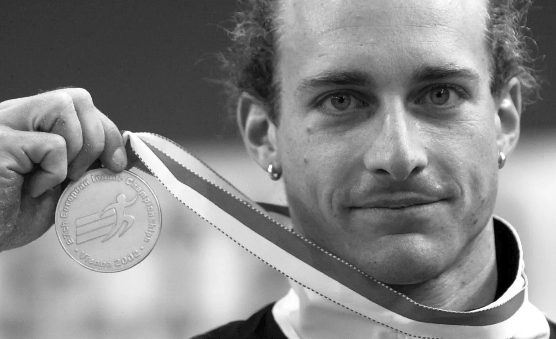 Der deutsche Stabhochspringer Tim Lobinger zeigt am Samstag (02.03.2002) im Ferry-Dusika Stadion in Wien bei den Leichtathletik-Hallen-Europameisterschaften nach der Siegerehrung seine Medaille.