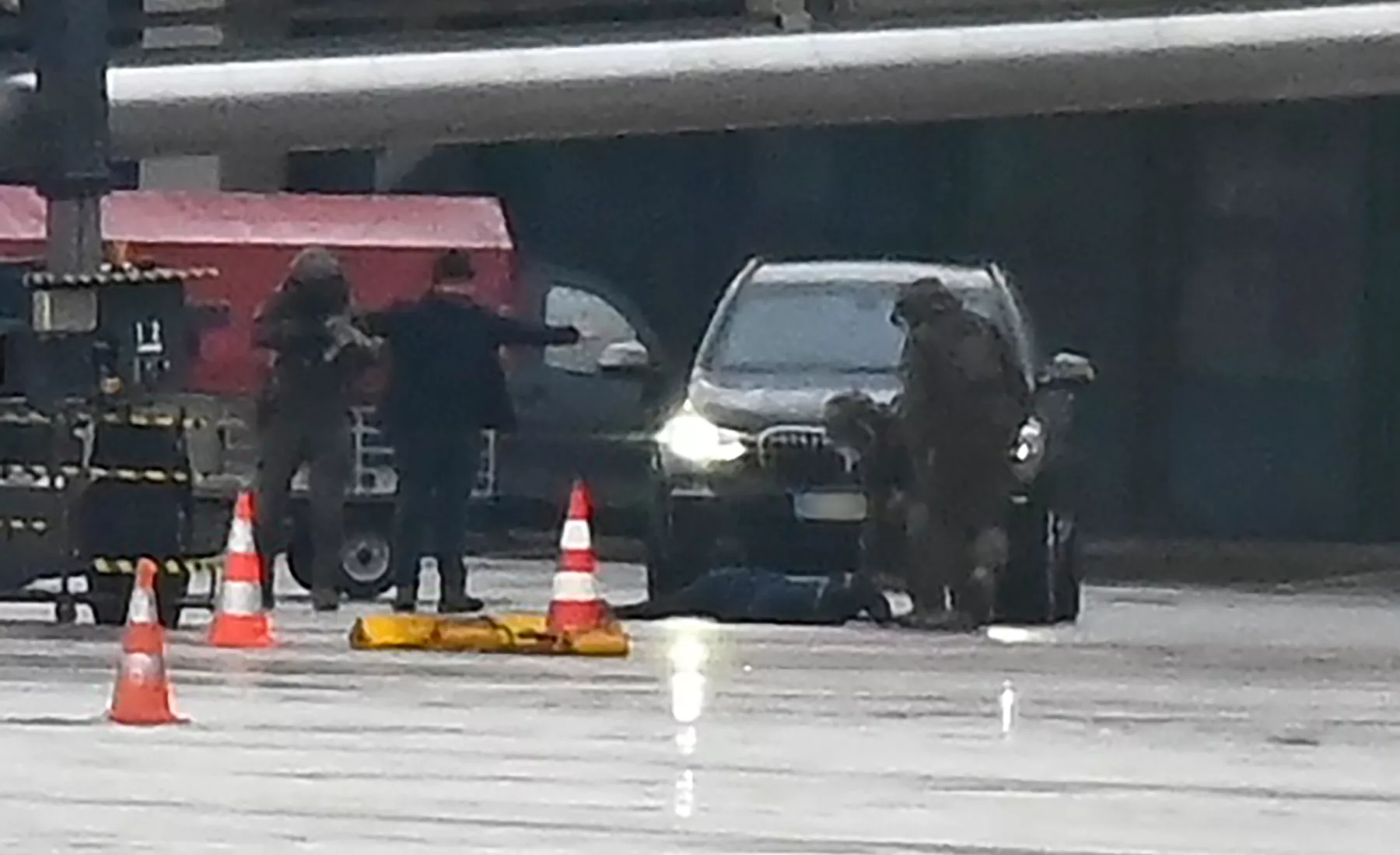 Ein Mann liegt auf dem Flughafen auf dem Boden, umringt von Polizeikräften