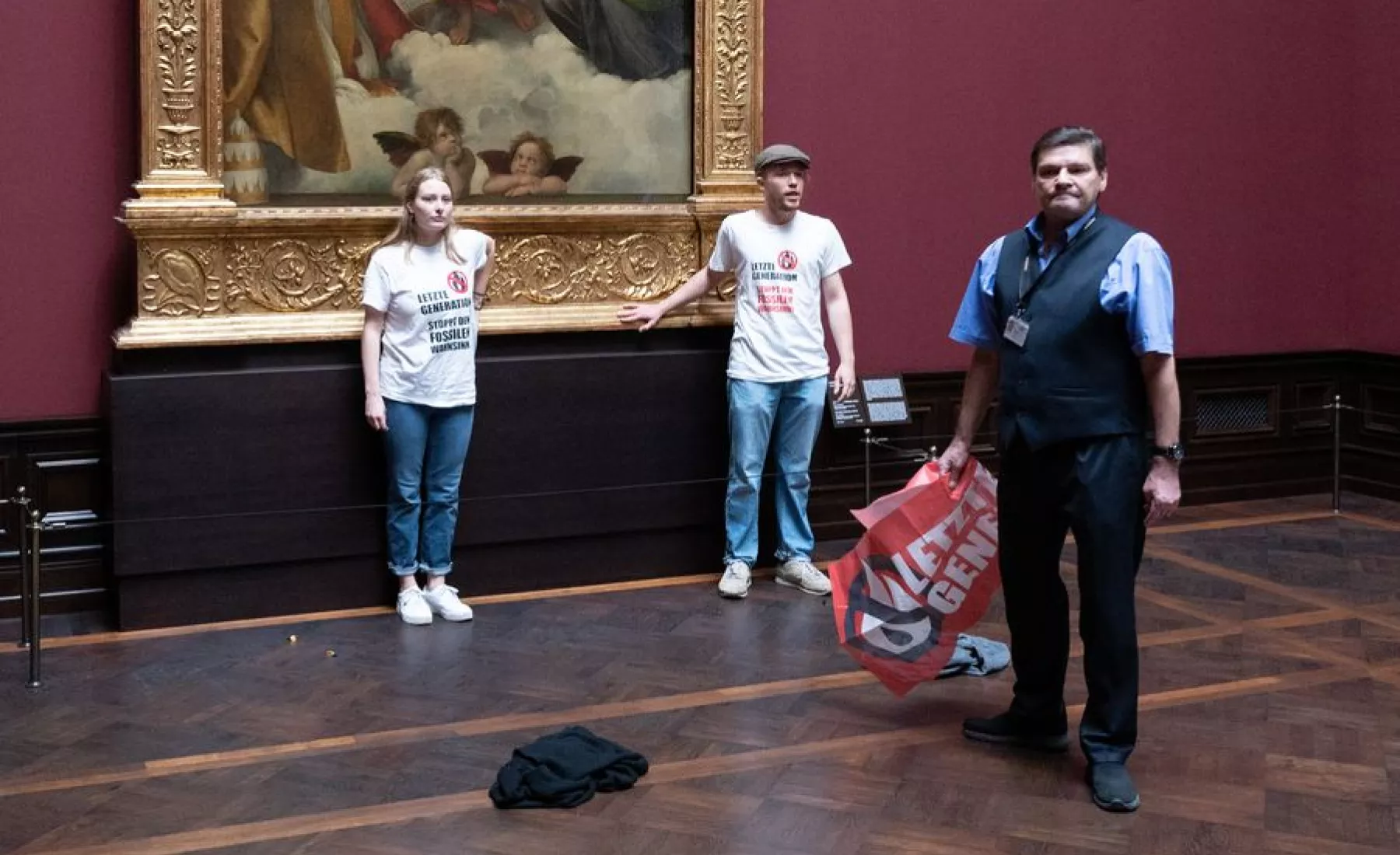 Zwei Umweltaktivisten der Gruppe „Letzte Generation“ stehen in der Gemäldegalerie Alte Meister an dem Gemälde „Sixtinische Madonna“ von Raffael