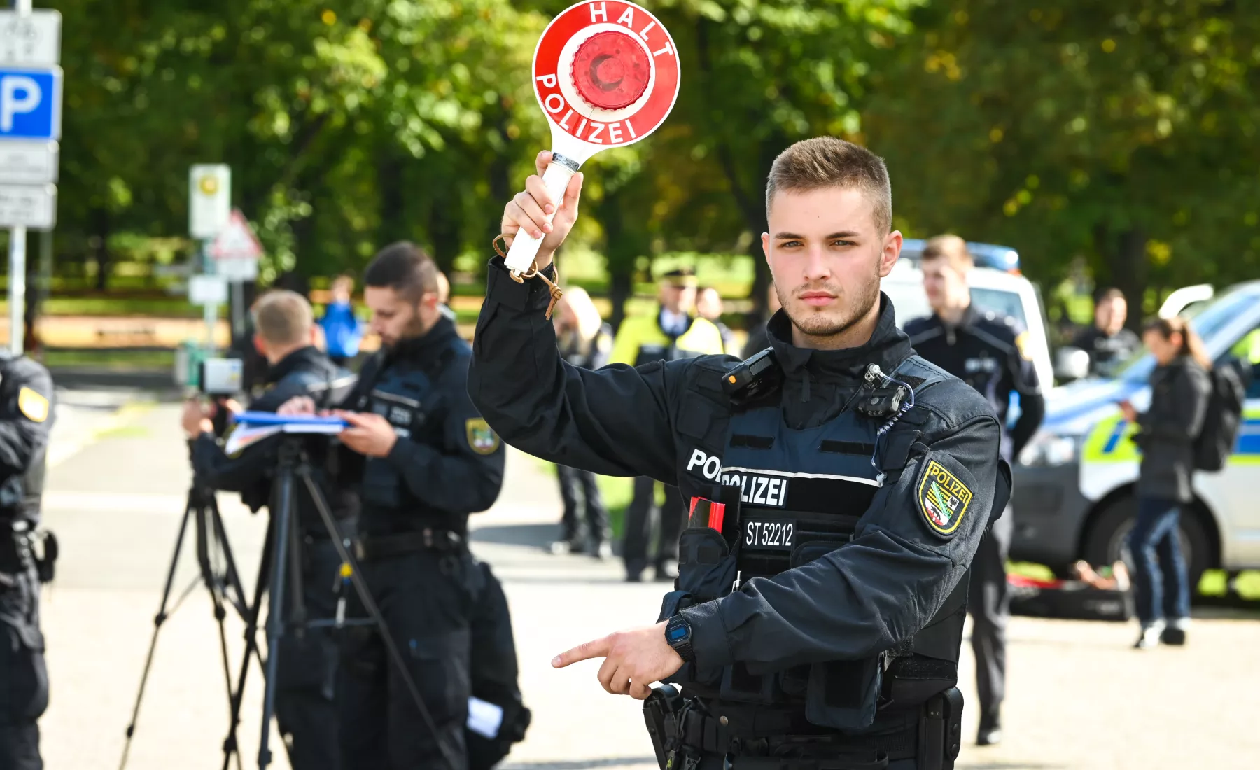 Ein Beamter des Zentralen Einsatzdienstes der Polizei hält eine Kelle.