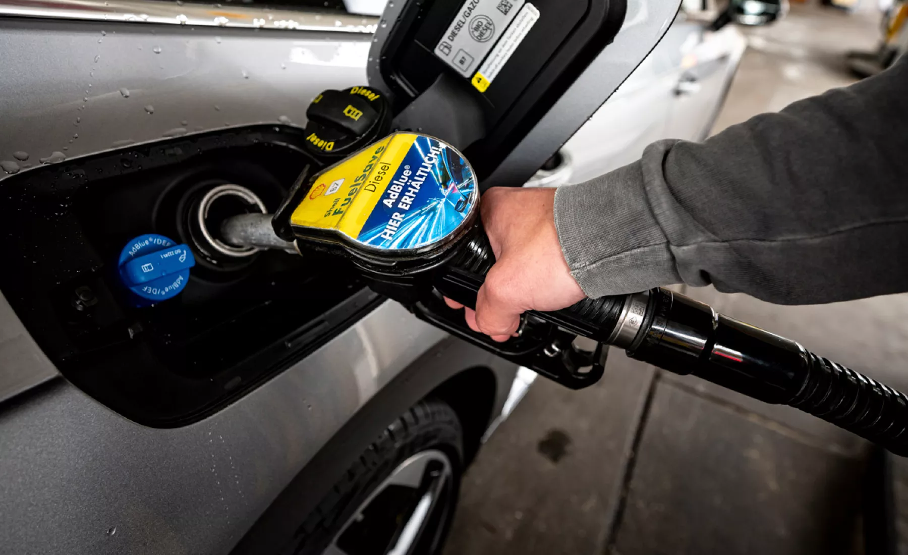Ein Mann betankt seinen Wagen mit Diesel-Kraftstoff. 