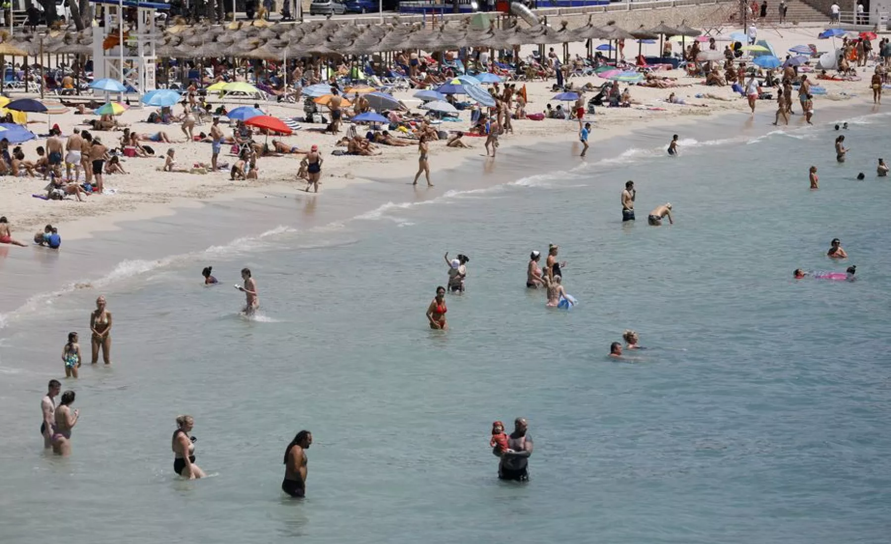 Menschen schwimmen und sonnen sich am Strand von Palmanova auf Mallorca