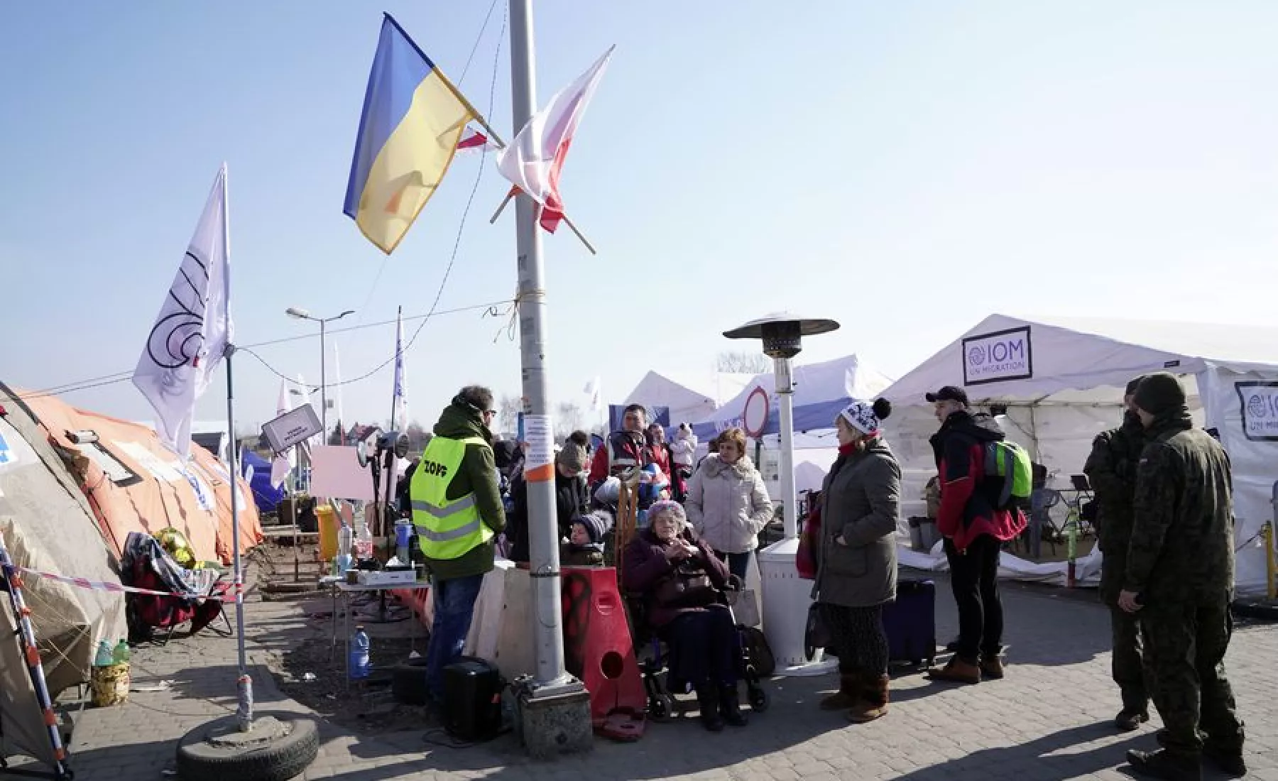 Ukrainische Flüchtlinge stehen bei ihrer Einreise nach Polen am Kontrollpunkt Medyka
