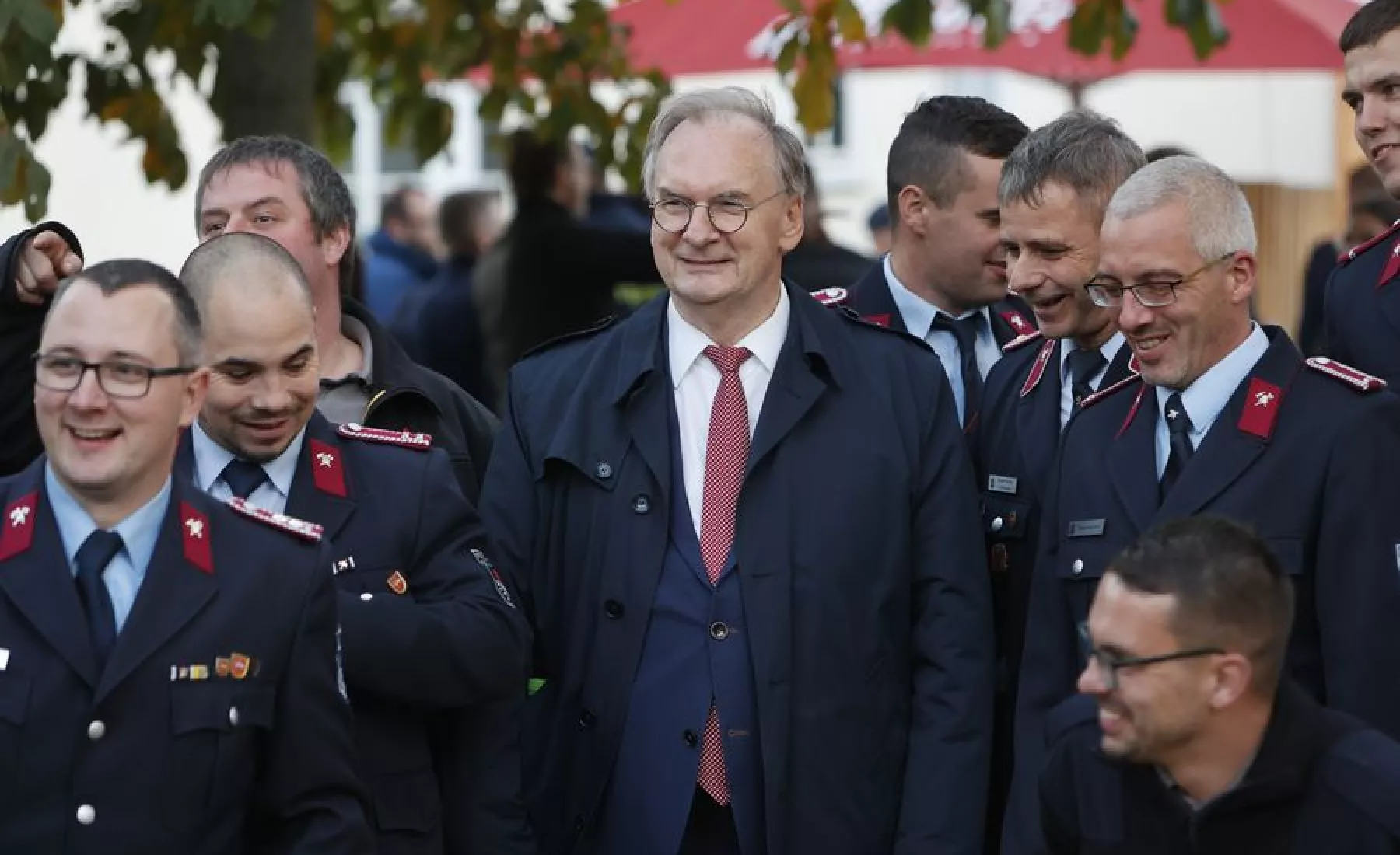 Ministerpräsident Reiner Haseloff , (CDU) steht im Bürgerpark neben Mitgliedern der Feuerwehr