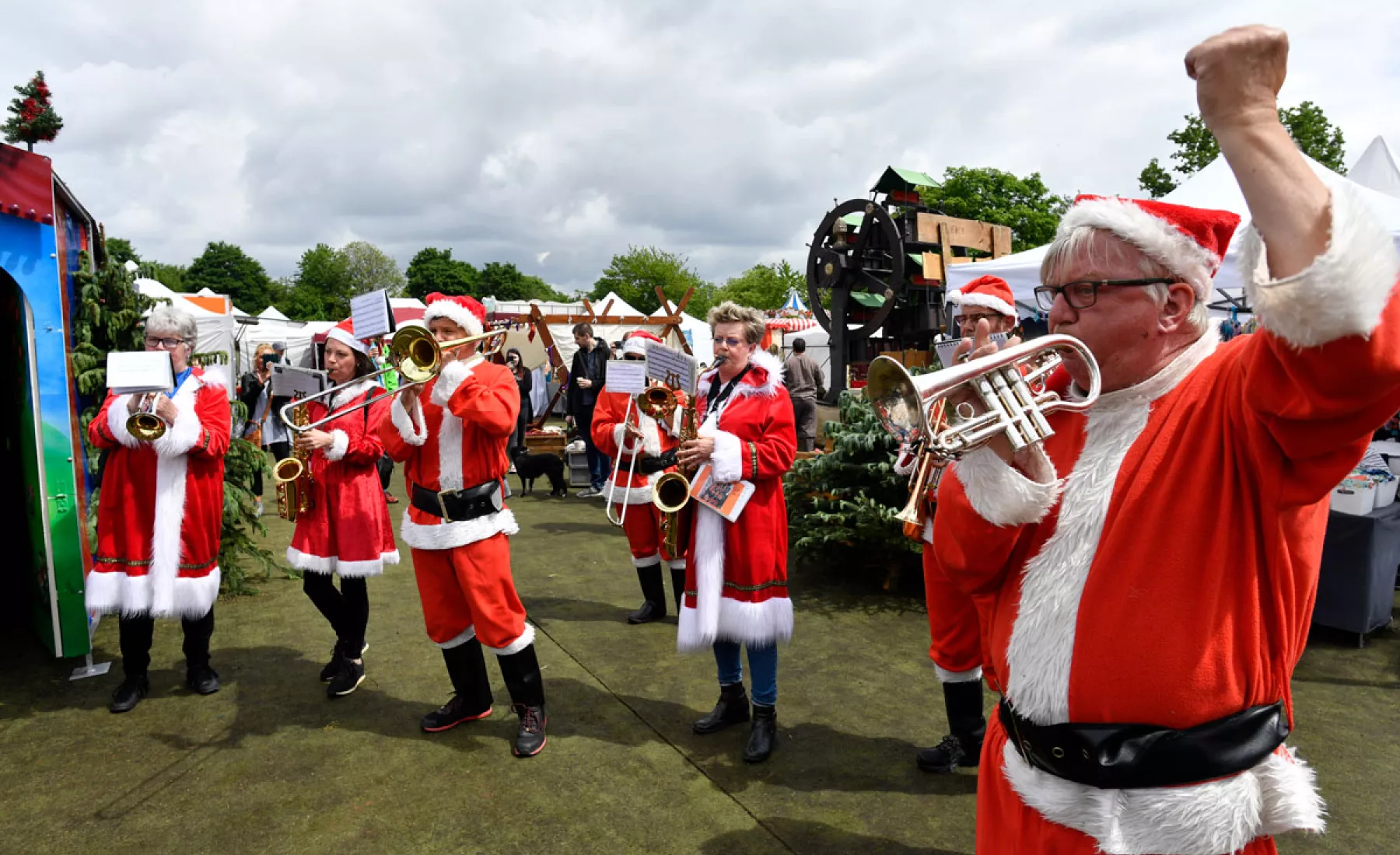 Musikkapelle in Weihnachtsmann-Kostümen spielt auf dem Weihnachtsmarkt in Schloss Burg