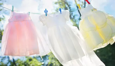 Pastellfarbene Wäsche hängt im strahlenden Sonnenschein auf einer Wäscheleine