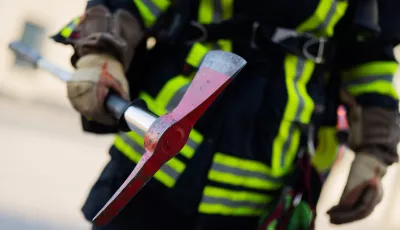 Ein Feuerwehrmann in Atemschutzausrüstung hält eine Axt