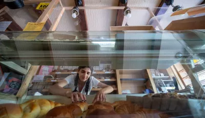 Mitarbeiterin Zübeyde ordnet die Ware in der Theke des Verkaufsraums der Bäckerei.