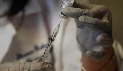 Apothekerin zieht Spritze auf mit dem Corona-Impfstoff von Biontech und Pfizer