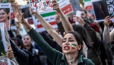 Eine Demonstrantin, die die Farben der iranischen Flagge auf der Wange geschminkt hat