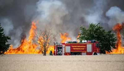  Ein Feuerwehrauto steht vor einem Feldbrand in der Nähe der Stadt Zörbig