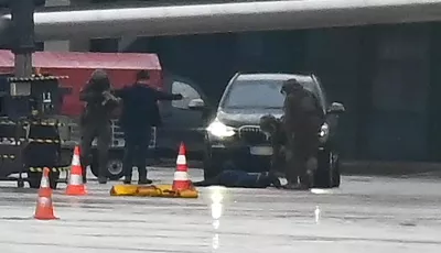 Ein Mann liegt auf dem Flughafen auf dem Boden, umringt von Polizeikräften