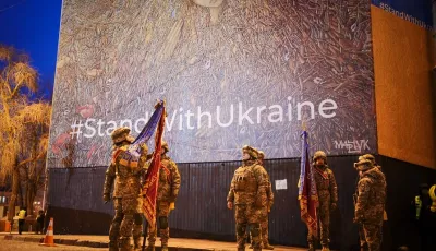 Ukrainische Soldaten stehen am frühen Morgen an der Sophienkathedrale unter einem Plakat mit der Aufschrift «Stand with Ukraine».
