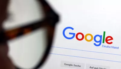 Die Seite der Suchmaschine von Google ist hinter einer Frau mit Brille zu sehen