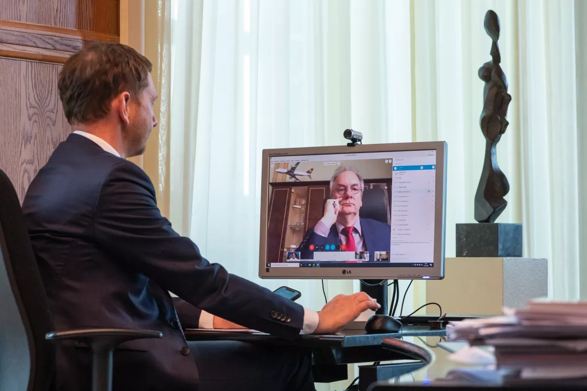 Michael Kretschmer (CDU), Ministerpräsident von Sachsen, sitzt in einem Büro in der Staatskanzlei vor einem Computerbildschirm und spricht während einer Schaltkonferenz per Video mit Reiner Haseloff, Ministerpräsident Sachsen-Anhalt (CDU). 