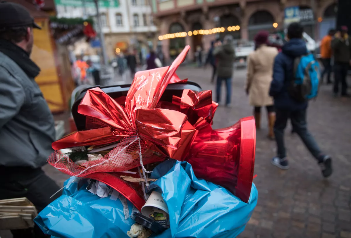 Eine rote Glocke und eine Schleife, die einen Stand auf dem Weihnachtsmarkt dekoriert hatten, liegen beim Abbau des Marktes im Müll