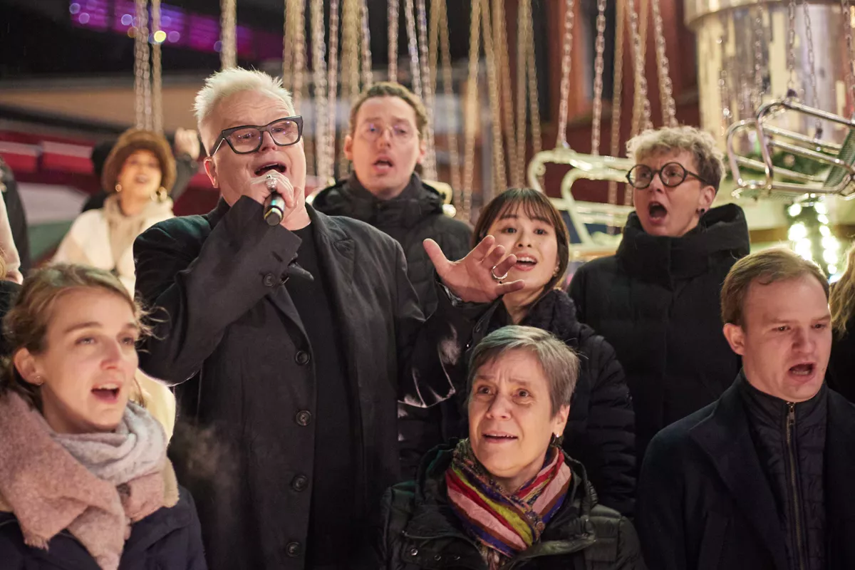 10.12.2023, Berlin: Bei einem Flashmob singt Herbert Grönemeyer mit dem Rundfunkchor sein neues Lied "Kaltes Berlin" auf dem Lucia Weihnachtsmarkt in der Kulturbrauerei. 