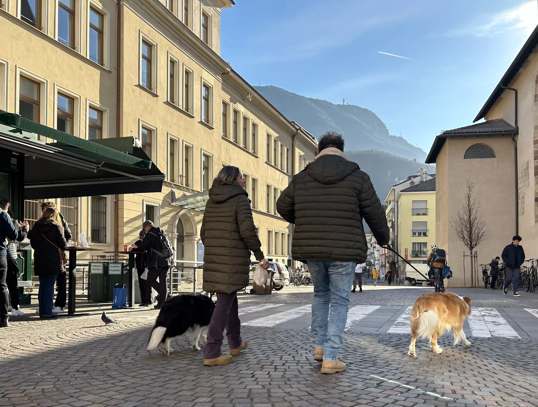 Hundehalter gehen mit ihren Tieren in den Straßen von Südtirols Hauptstadt Bozen spazieren