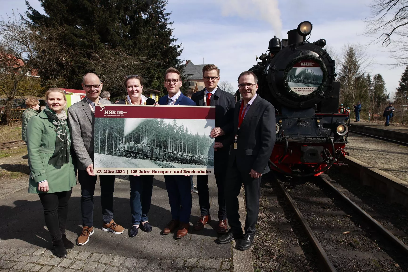 Katrin Müller (l), Geschäftsführerin der Harzer Schmalspurbahnen GmbH (HSB), steht mit einer Reihe von offiziellen Teilnehmern vor einem Sonderzug der HSB im Bahnhof Drei Annen Hohne