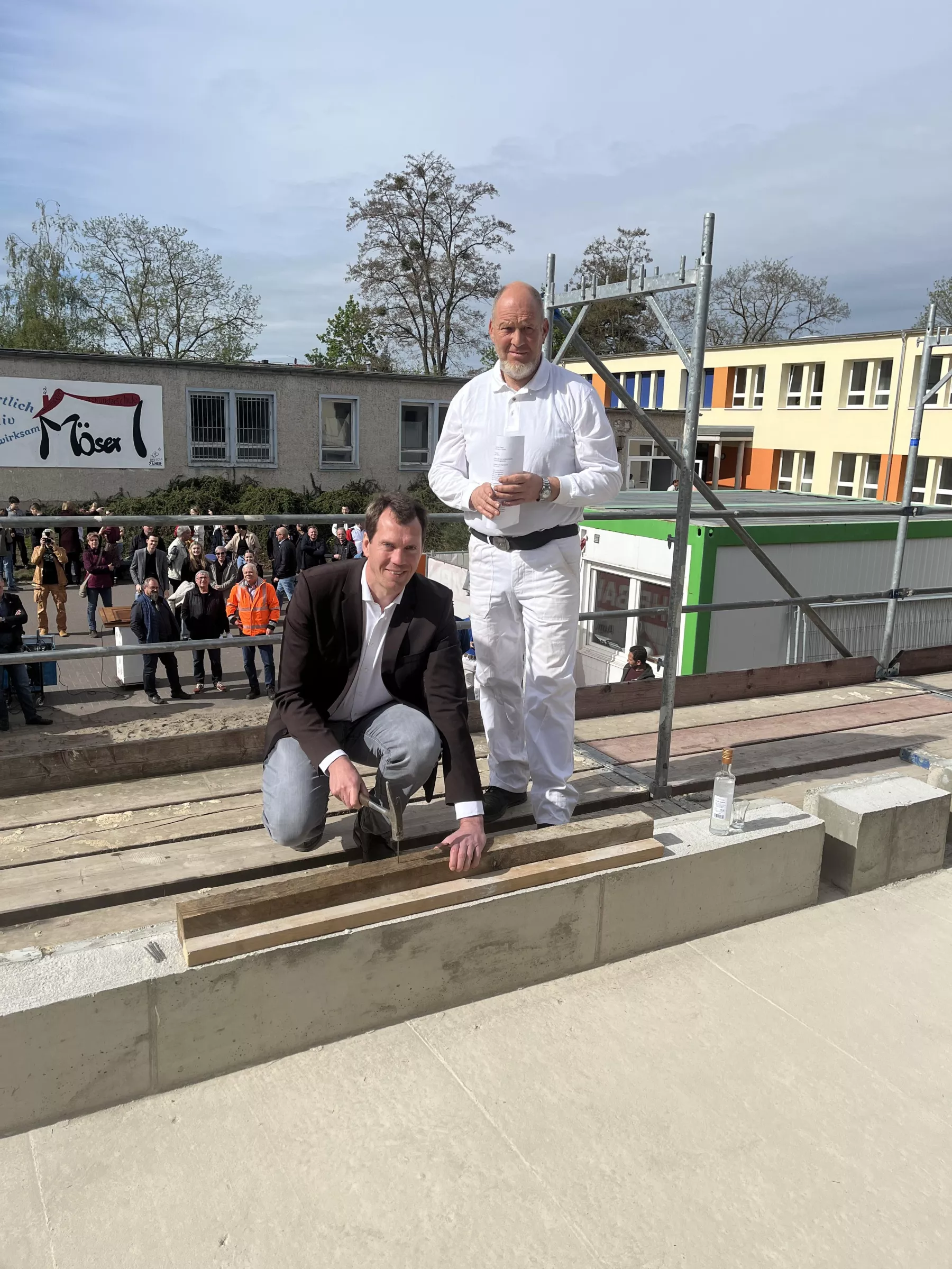 Im Beisein von Sven Herrmann (Polier Fa. HB-Bau GmbH, rechts im Bild), der zuvor den Richtspruch verlas, schlägt Landrat Dr. Steffen Burchhardt den symbolischen letzten Nagel in den Balken.